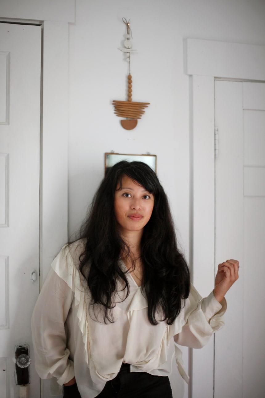 Kim in her apartment. Wall hanging by Katherine Moes